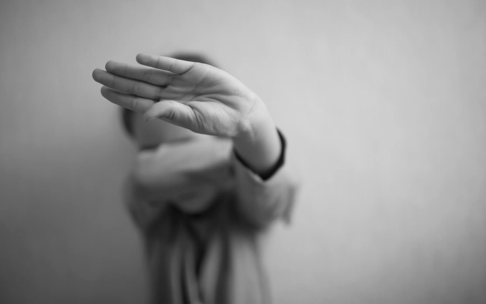 Ein kleines Mädchen schützt sich mit ihrer Handfläche und bedeckt ihr Gesicht