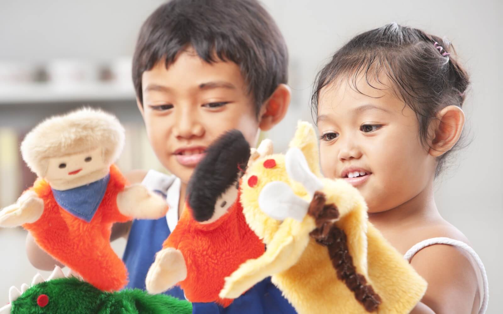 Geschwister spielen mit Handpuppen