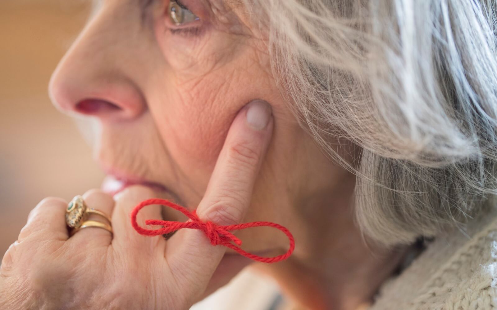 Close Up Of Senior Woman mit Schnur um Finger als Erinnerung