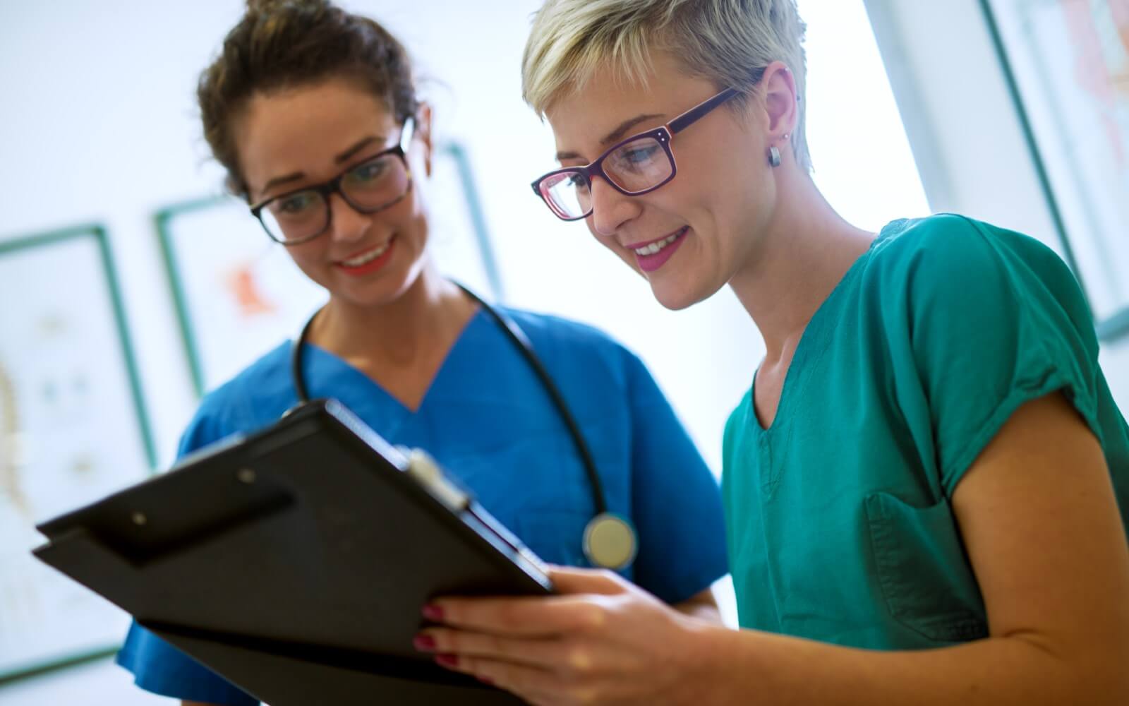 Pflegefachkraft und Pflegehilfskraft mit Dokumentation eines Patienten.